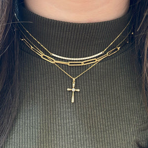 Female Model Wearing Diamond & Gold Rounded Cross Pendant Necklace  An ideal christening, communion, confirmation, birthday, or holiday gift.  -14K gold weighing 1.57 grams  -8 round prong-set diamonds totaling 0.09 carats