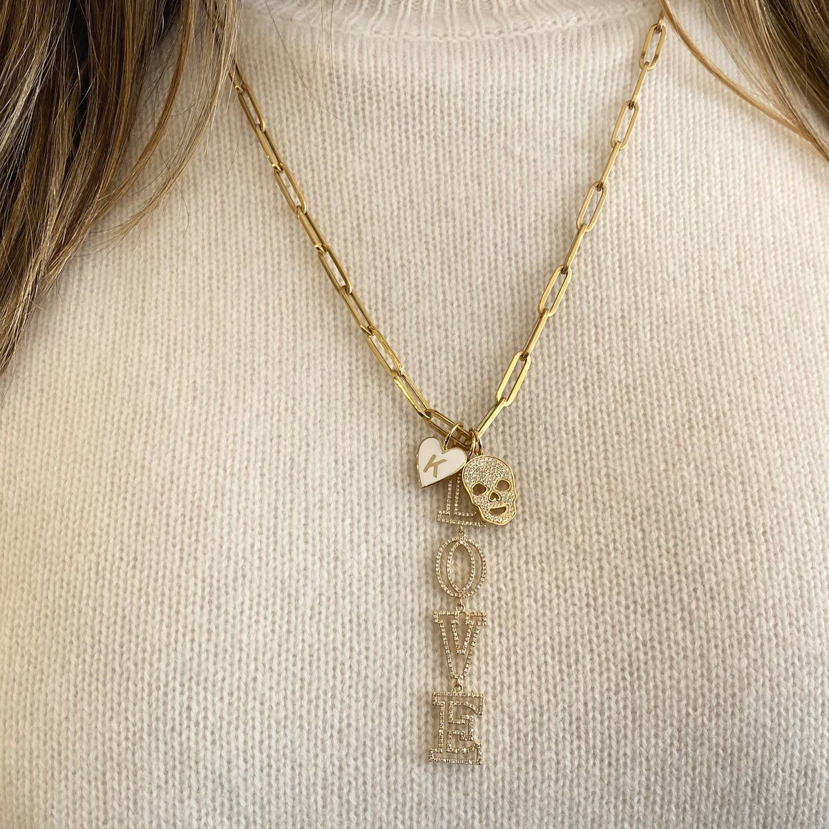 Female model wearing Diamond Skull Pendant - 14K gold weighing 2.63 grams - 103 round diamonds totaling 0.28 carats