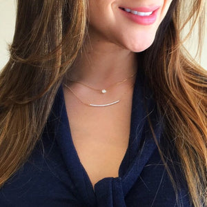 Female model wearing Curved Diamond Bar Necklace -14K gold weighing 2.9 grams -29 round diamonds totaling 0.43 carats 2mm in width, 2 inches length.