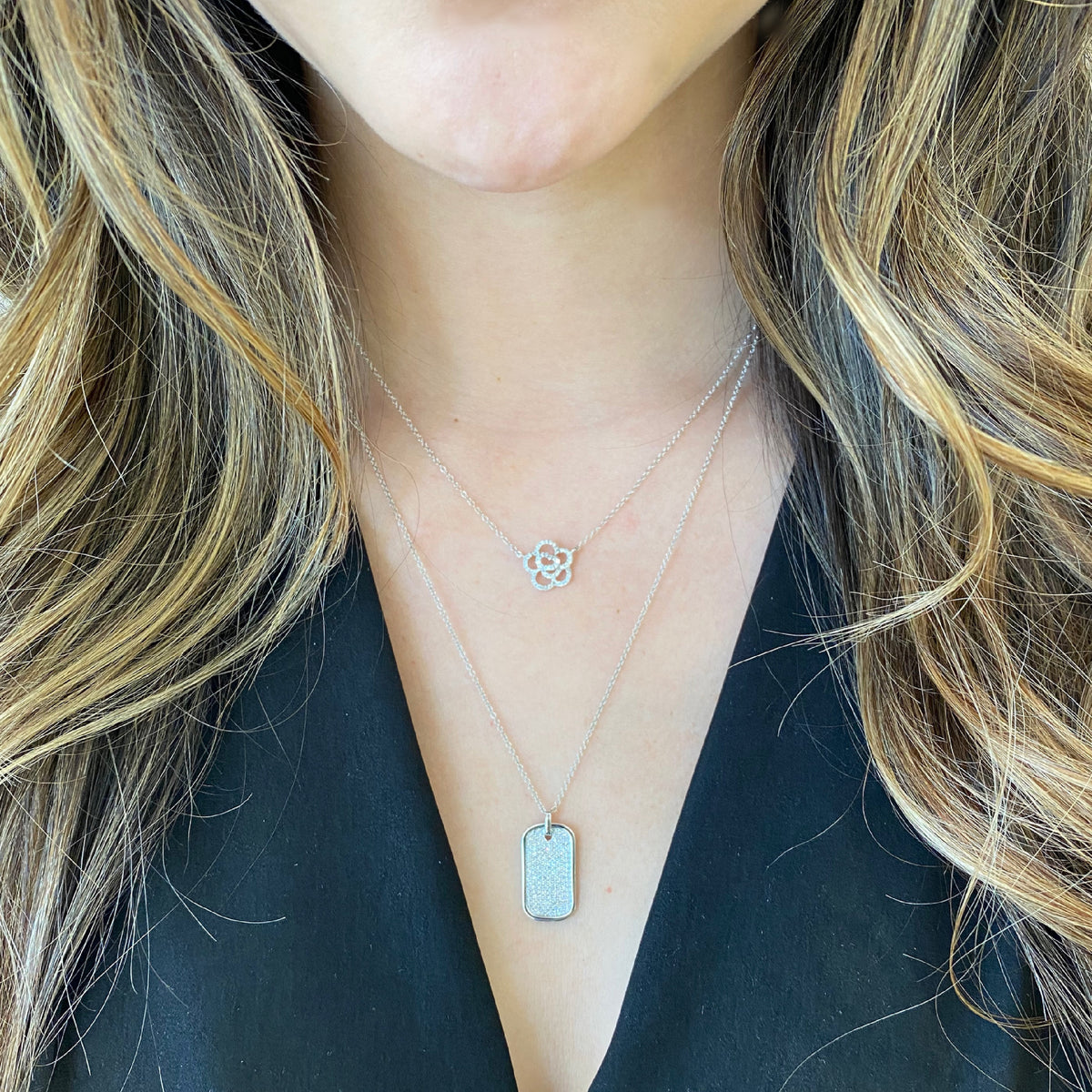 Female Model Wearing Diamond Flower Outline Pendant Necklace  -14K gold weighing 2.00 grams  -52 round pave-set diamonds totaling 0.16 carats