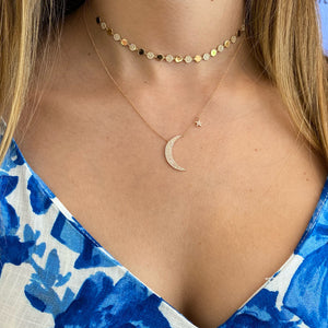 Female model wearing Pave Diamond Moon and Star Necklace  -14K yellow gold weighing 2.50 grams  -125 round pave-set diamonds totaling 0.27 carats.