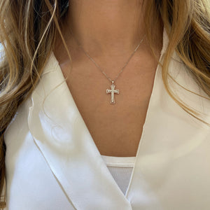 Female Model Wearing Diamond Cross Pendant Necklace with Gold Halo  An ideal christening, communion, confirmation, birthday, or holiday gift!  -14K gold weighing 3.35 grams  -21 round diamonds totaling 0.25 carats.