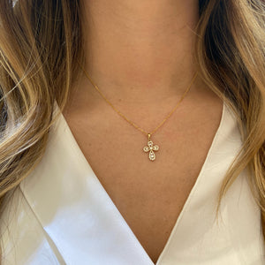 Female Model Wearing Diamond Mini Rounded Cross Pendant  -14K gold weighing 2.79 grams  -46 round prong-set brilliant diamonds totaling 0.42 carats