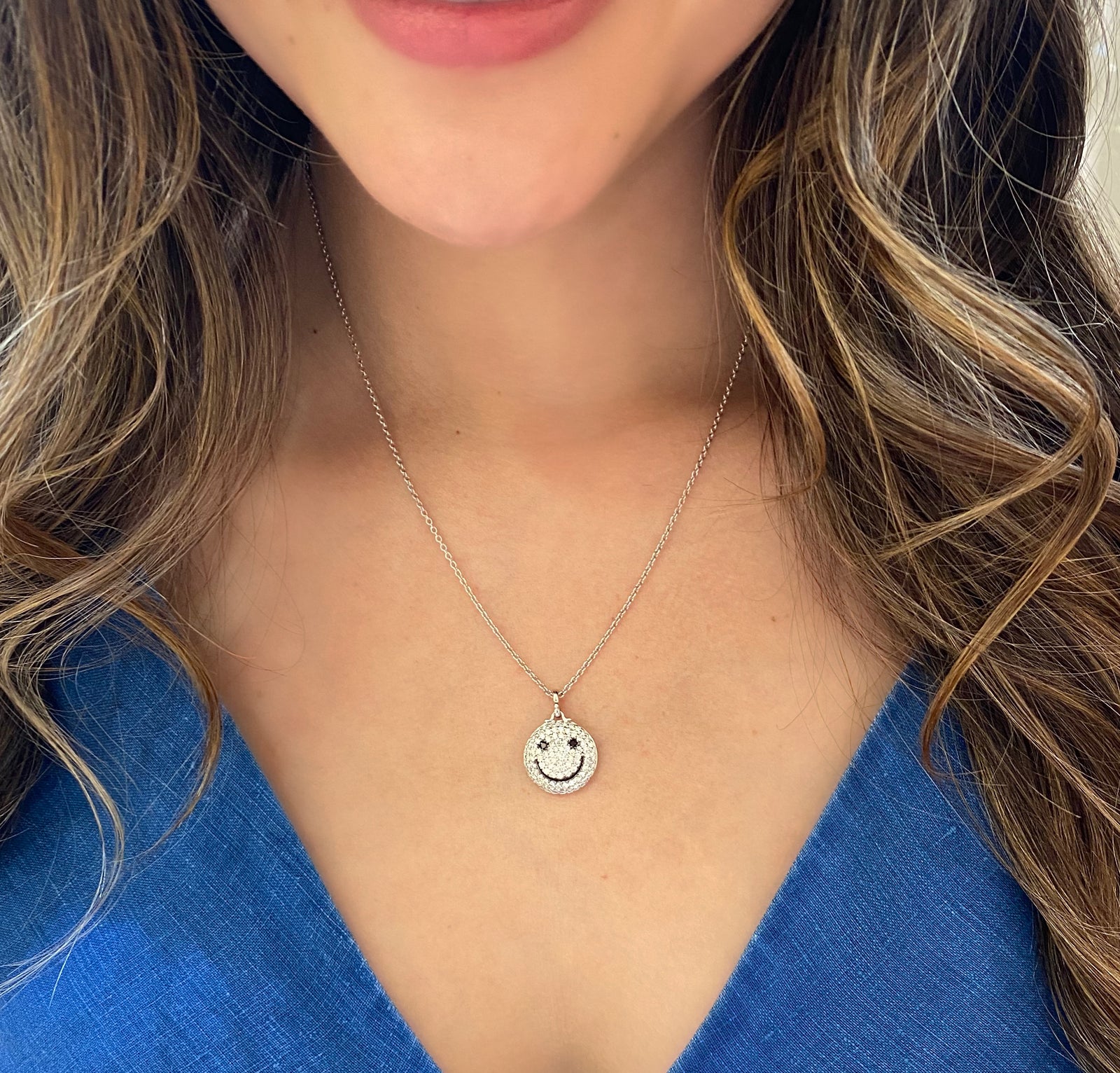 Diamond Smile Pendant     - 14k gold weighting 8.80 grams.  - 92 round prong-set diamonds .95 carats, 2 black round prong-set diamonds .06 carats.  Size 17 millimeters diameter.