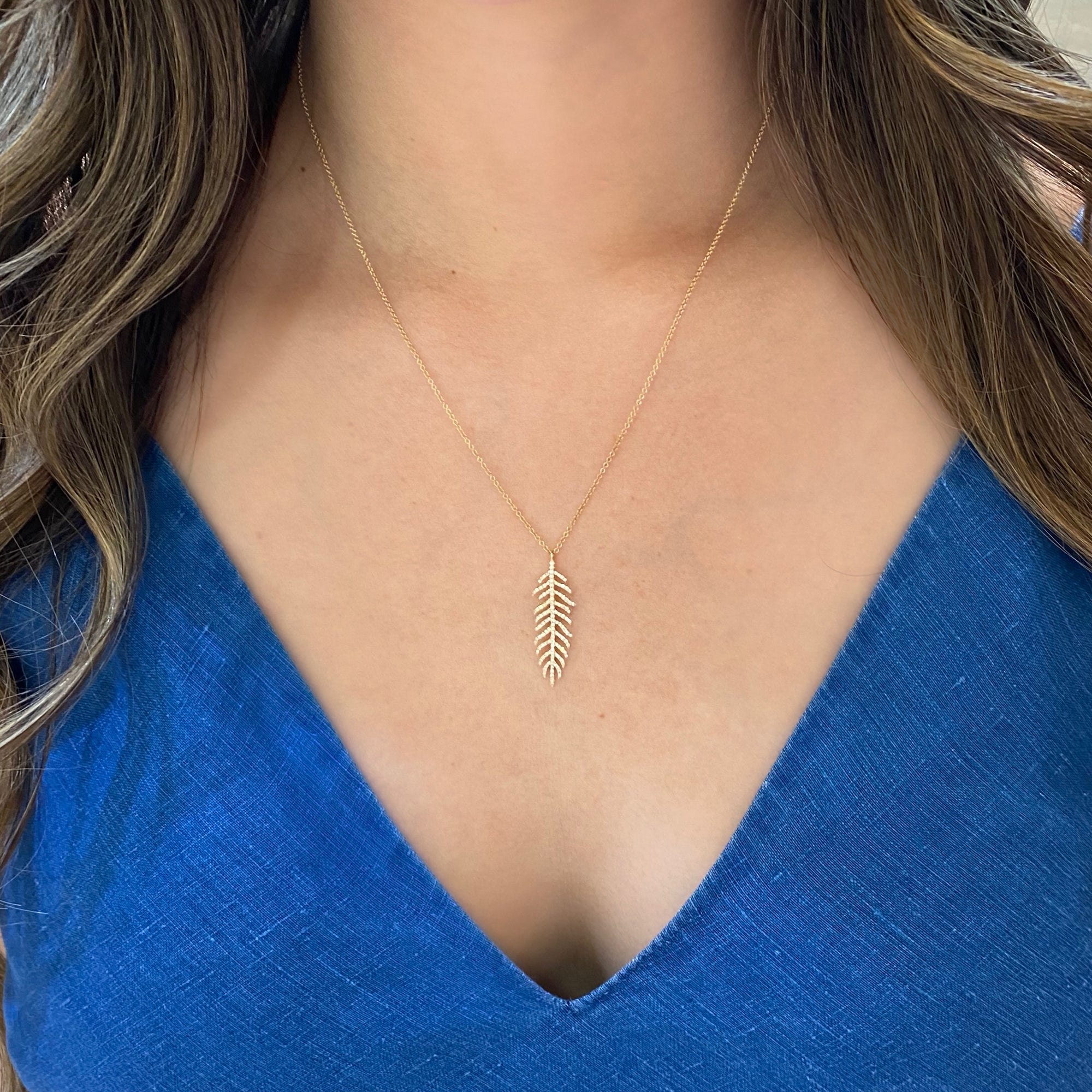 Diamond Feather Pendant Necklace  - 14K gold weighing 2.25 grams.  - 126 round diamonds totaling 0.30 carats.