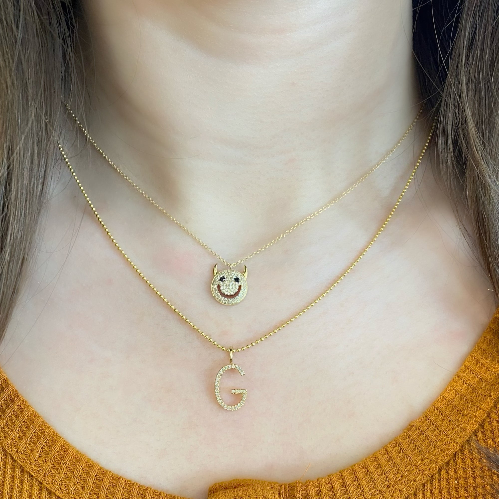 Solid 14k yellow gold weighing 2.51 grams with 96 round diamonds weighing .21 carats and 2 black round diamonds weighing .03 carats Devil Smiley Face Pendant Necklace | Nuha Jewelers