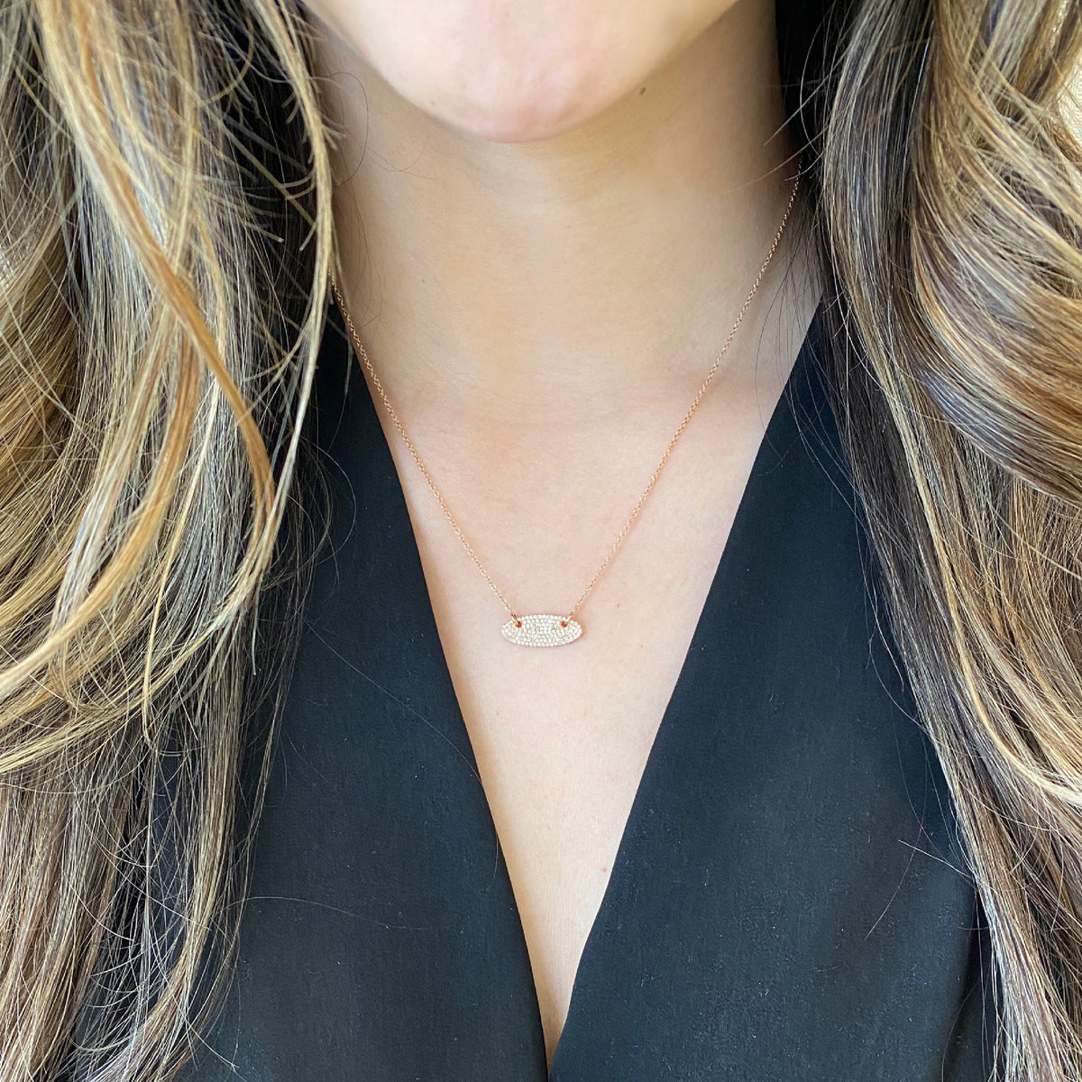 Female Model Wearing Pave Diamond Vertical Oval Pendant Necklace  -14k gold weighing 2.53 grams  -118 round diamonds weighing .27 carats