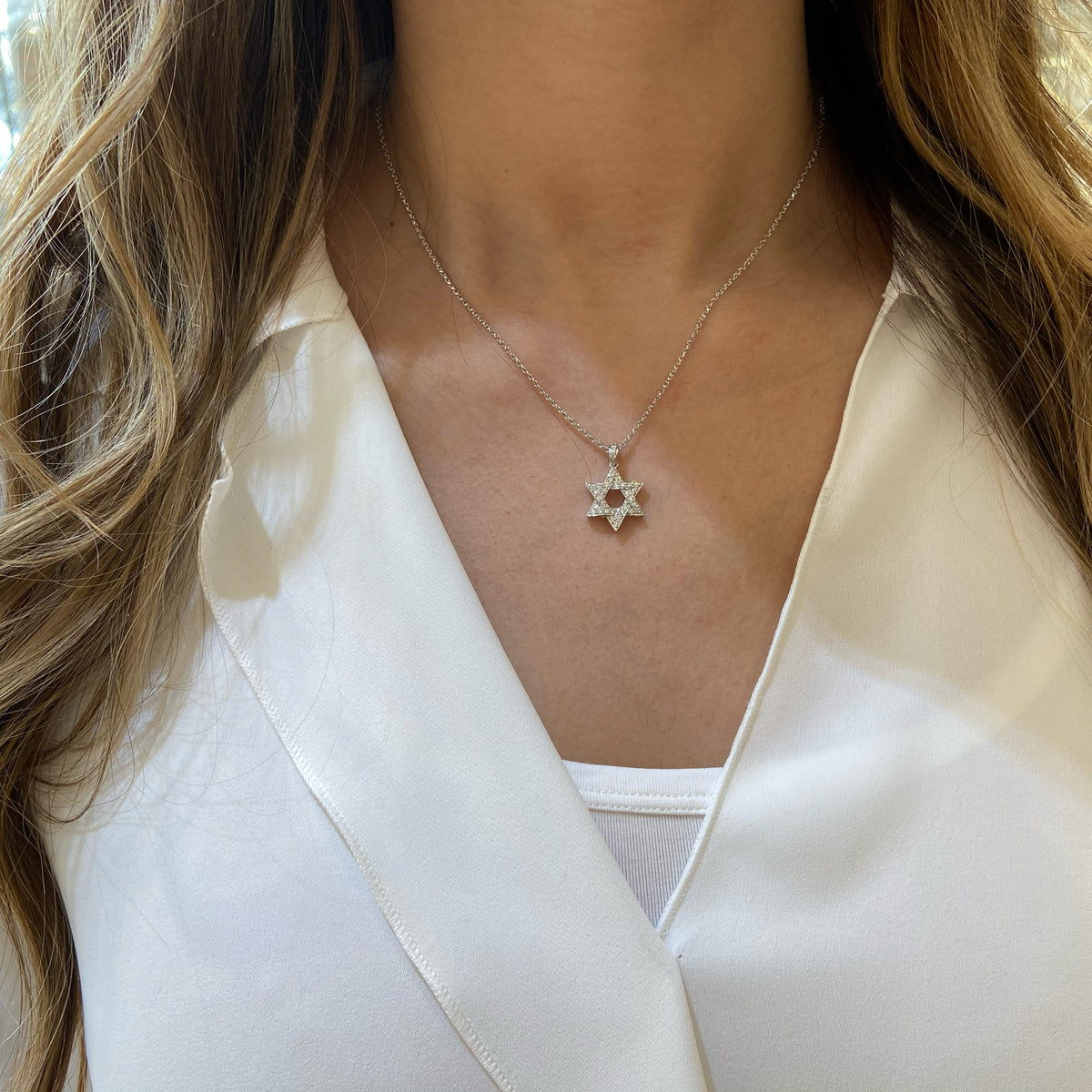 Female Model Wearing Diamond Star of David Pendant with Diamond Bail  -14K gold weighing 4.05 grams  -33 round pave-set diamonds totaling 0.32 carats