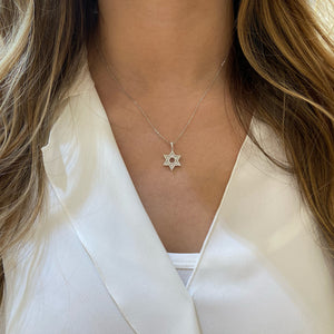 Female Model Wearing Diamond Star of David Pendant with Diamond Baguettes  -18K gold weighing 1.57 grams  -71 round pave-set diamonds totaling 0.21 carats  -12 pave-set baguettes totaling 0.25 carats