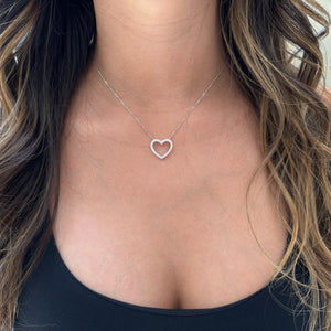 Female Model Wearing Diamond Heart Cutout Pendant Necklace  -14K gold weighing 3.3 grams  -26 round shared prong-set brilliant diamonds totaling 0.75 carats  -Chain measures 16 inches.