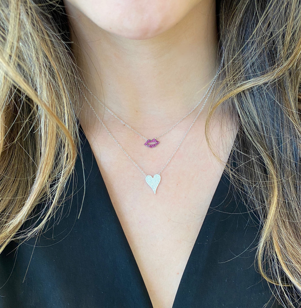 Female model wearing Diamond Small Elongated Heart Necklace  -14K yellow gold weighing 1.95 grams  -73 round pave set diamonds totaling 0.21 carats.