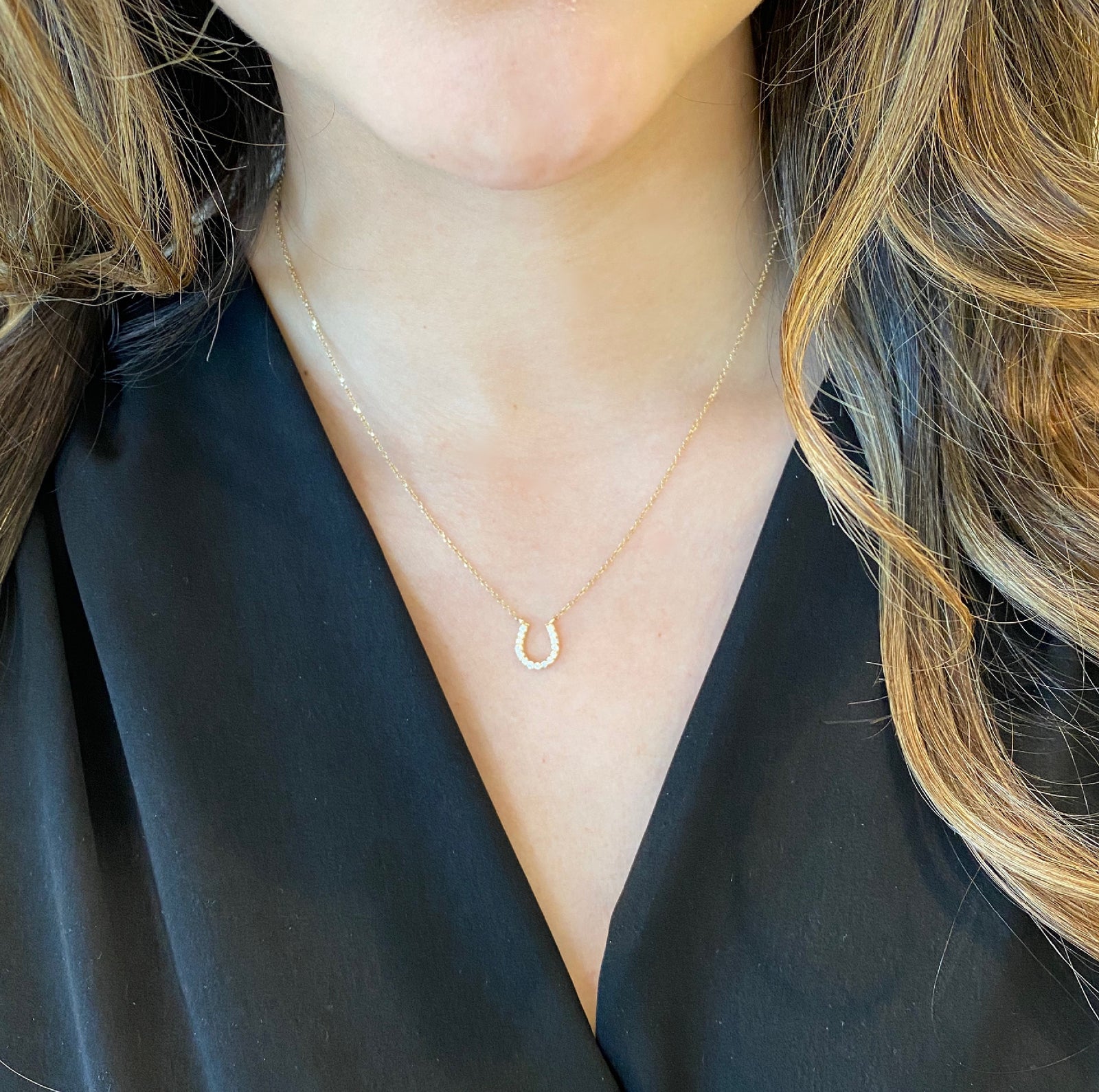 Diamond Horseshoe Pendant Necklace  -14K yellow gold weighing 1.8 grams  -15 round diamonds totaling 0.15 carats   -adjustable 16"-18" chain