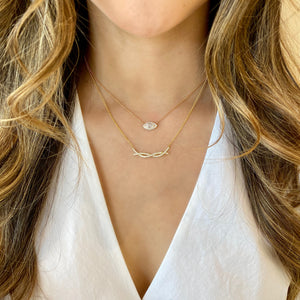 Female Model Wearing Diamond Halo Necklace for Marquise Solitaire  14k gold, 3.37 grams, 16 round shared prong-set diamonds .19 carats, 1 marquise prong set diamond weighing .60 carats.  Size length 13 millimeters, width 7 millimeters.  Stone size length 8 millimeters, width 4 millimeters.