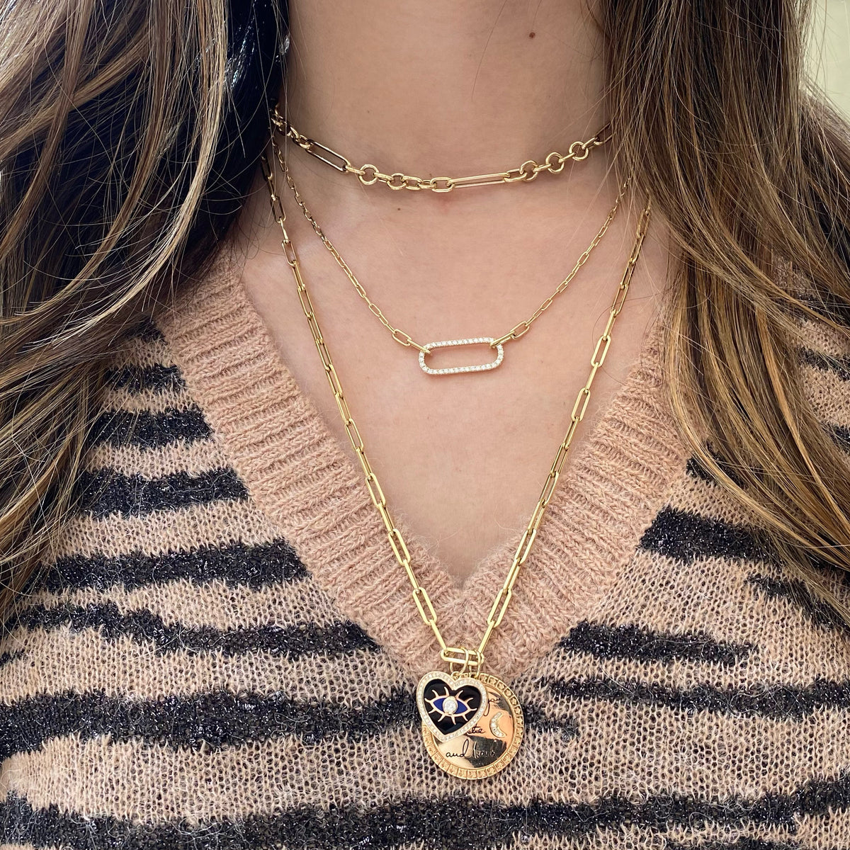 Female model wearing Diamond & Enamel Evil Eye Heart Pendant - 14K gold weighing 2.59 grams - 51 round diamonds totaling 0.22 carats