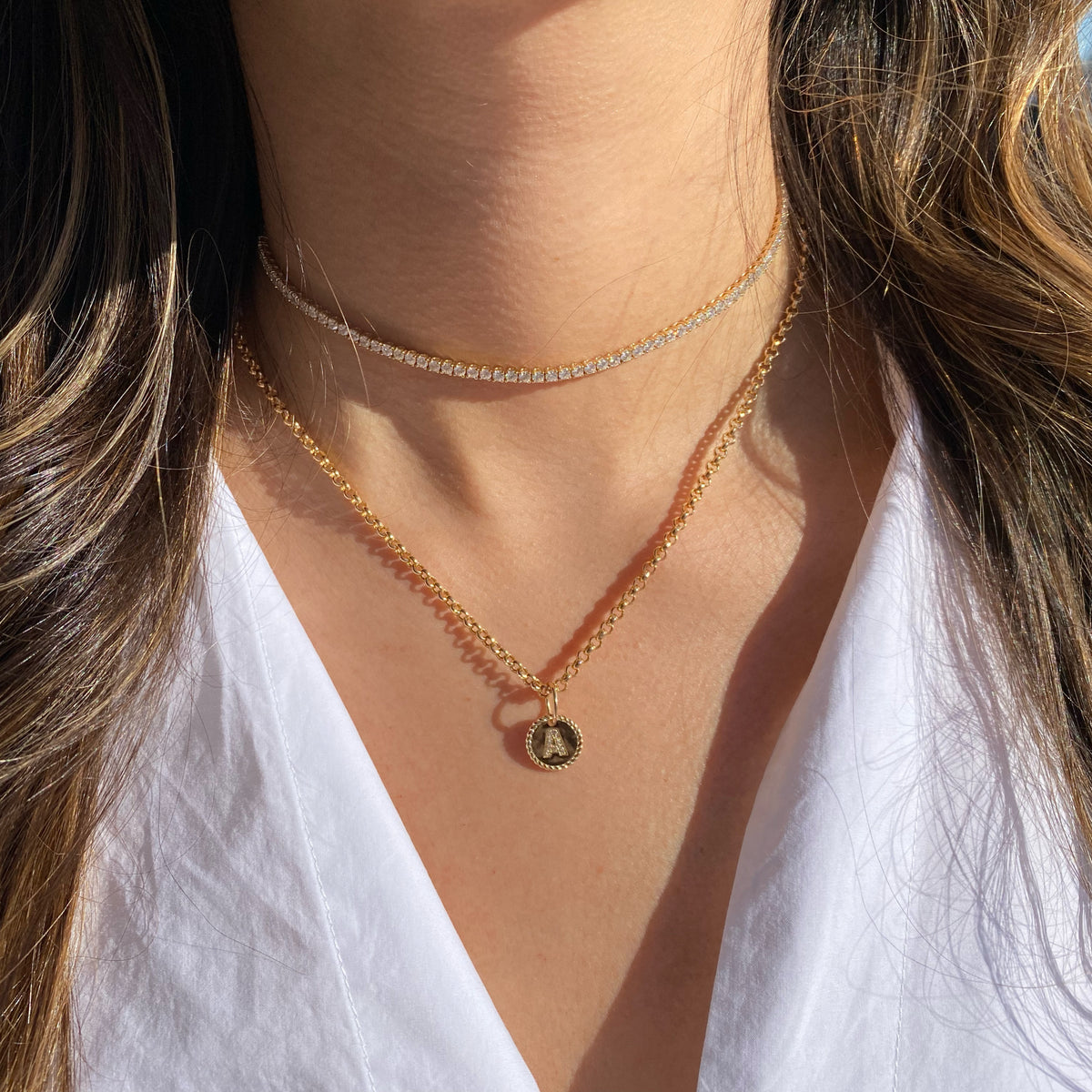 Female Model Wearing Diamond Round Initial Charm  - 14K gold weighing 1.52 grams  - 11 round diamonds totaling 0.03 carats