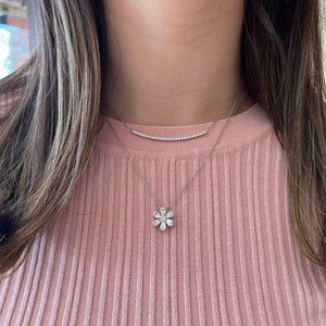 Female Model Wearing Round and Baguette Diamond Flower Pendant - 18K gold weighing 4.07 grams - 25 round diamonds weighing 0.13 carats - 12 slim baguettes weighing 0.64 carats | Nuha Jewelers