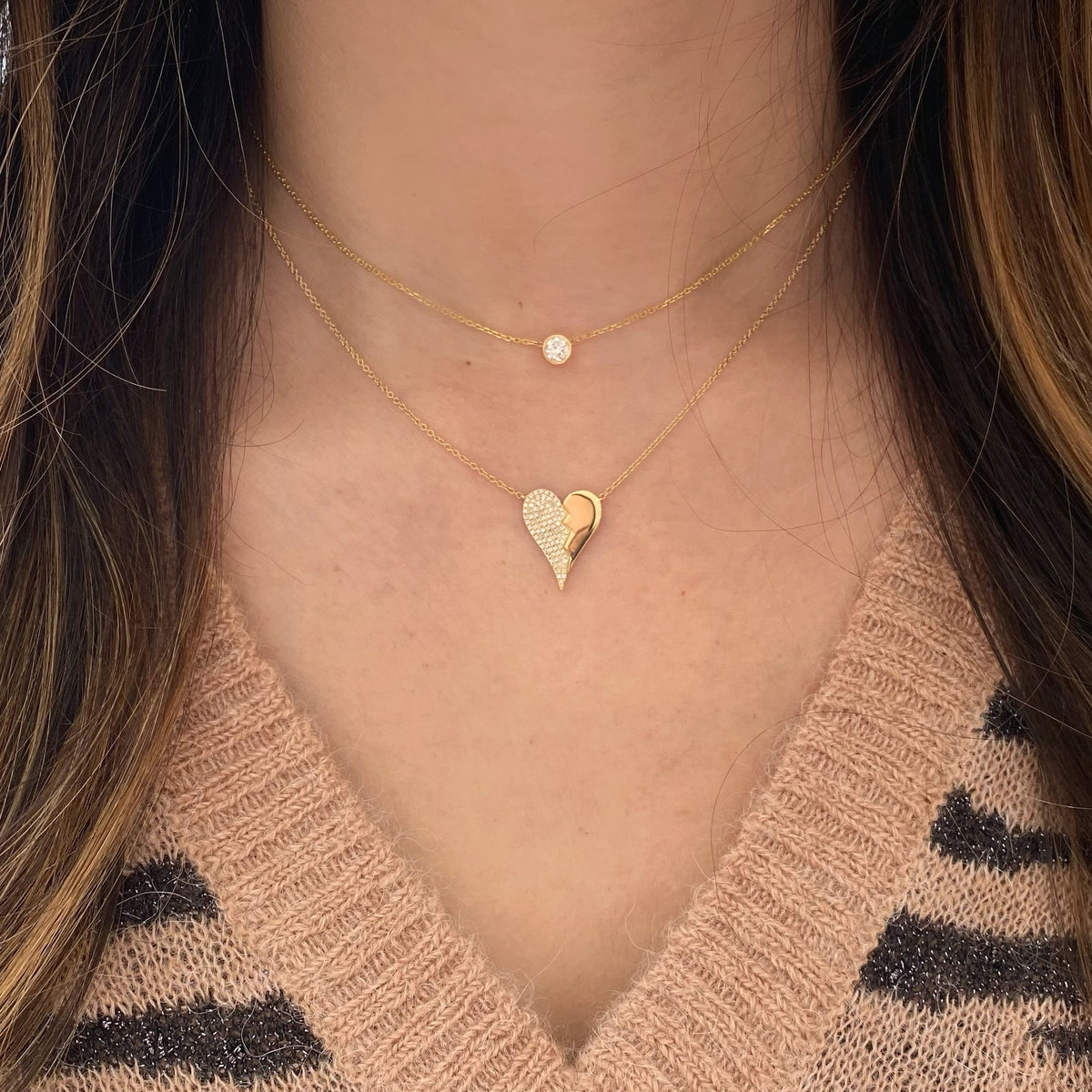Female model wearing Diamond Broken Heart Pendant - 14K gold weighing 3.05 grams - 90 round diamonds totaling 0.24 carats