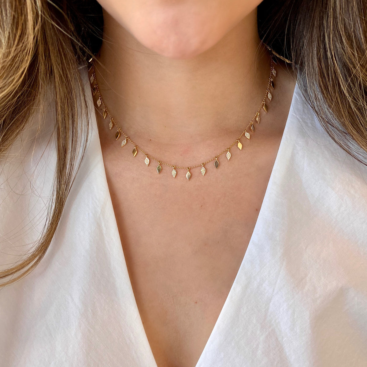 Female Model Wearing Diamond & Gold Leaf Dangle Necklace  -14K gold weighing 6.97 grams  -180 round diamonds totaling 0.42 carats