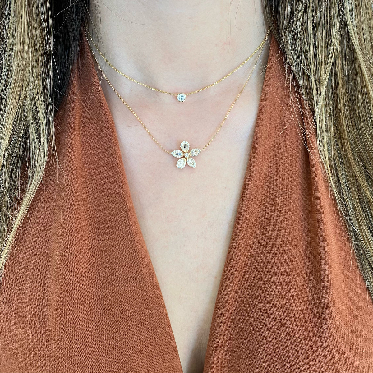 Female model wearing Baguette Diamond Flower Necklace - 14K gold weighing 3.45 grams - 20 slim baguettes totaling 0.29 carats - 46 round diamonds totaling 0.38 carats