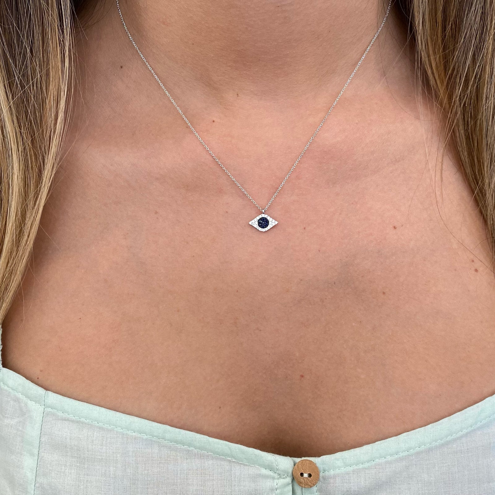 Sapphire & Diamond Evil Eye Pendant  - 14K gold weighing 1.67 grams  - 22 round diamonds totaling 0.13 carats  - 7 sapphires totaling 0.08 carats