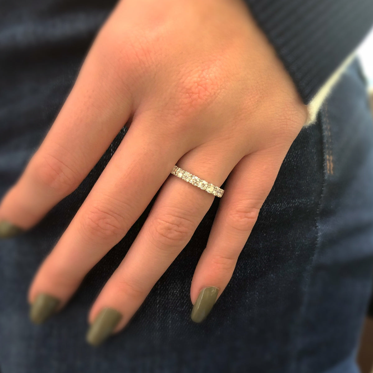 Female model wearing Classic Shared Prong-Set Diamond Eternity Band -18k gold weighing 3.07 grams -21 round diamonds weighing 2.05 carats