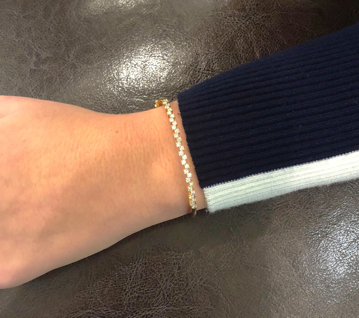 Female Model Wearing Diamond Zig-Zag Bangle Bracelet  -14K gold weighing 9.50 grams  -29 round diamonds totaling 1.00 carat