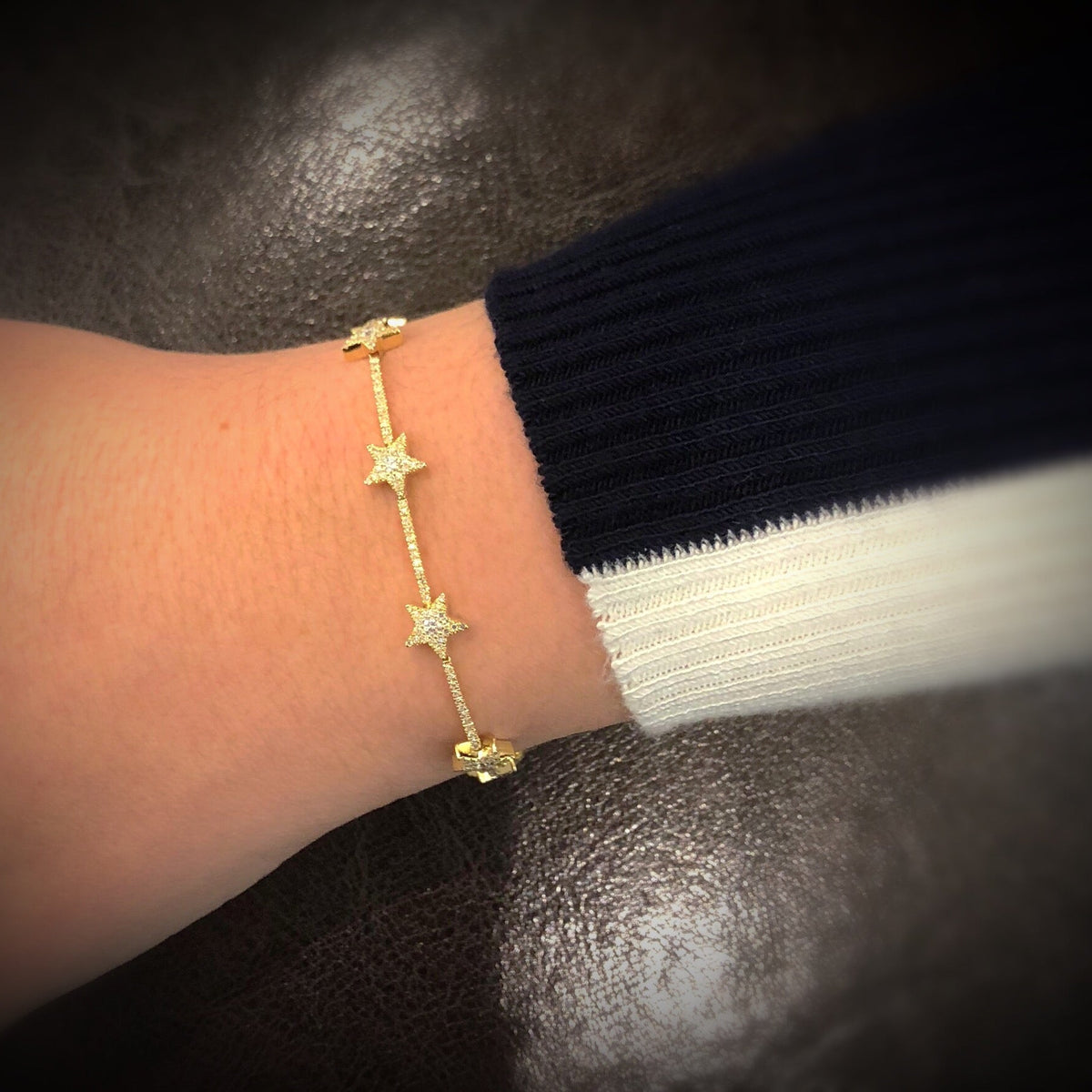 Female model wearing Diamond Stars Bracelet - 14K gold weighing 5.85 grams - 236 round shared prong-set diamonds totaling 0.86 carats. -7 round diamonds totaling .21 carats