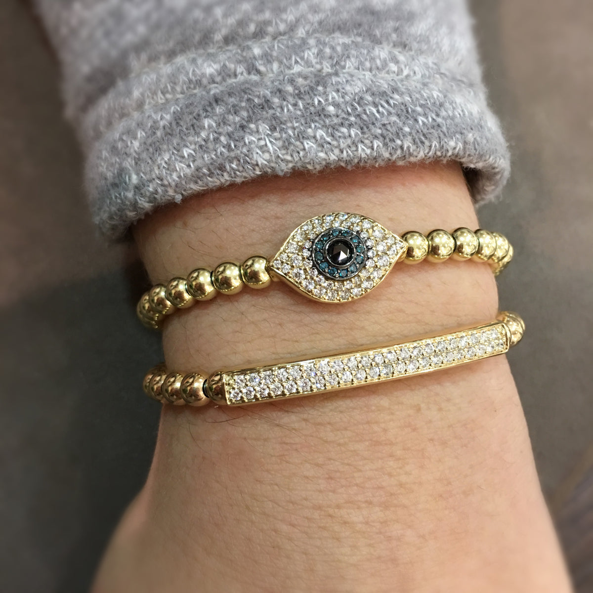 Female model wearing Pave-set Diamond Bar Stretch Bracelet - 14k gold, 13.2 grams, 43 round pave-set diamonds .68 carats. Size 48x58 millimeters, width 5 millimeters.