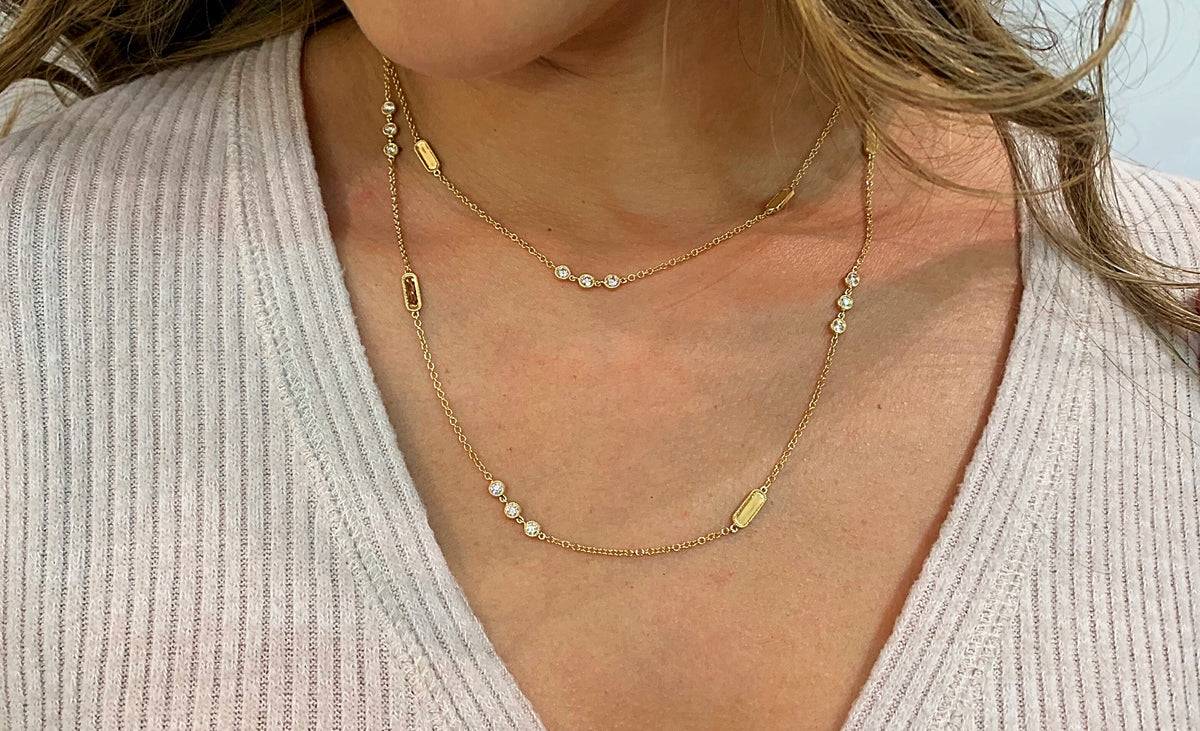 Female model wearing Layered Diamond Station Necklace -18k gold 11.91 grams -24 round bezel-set diamonds 1.78 carats