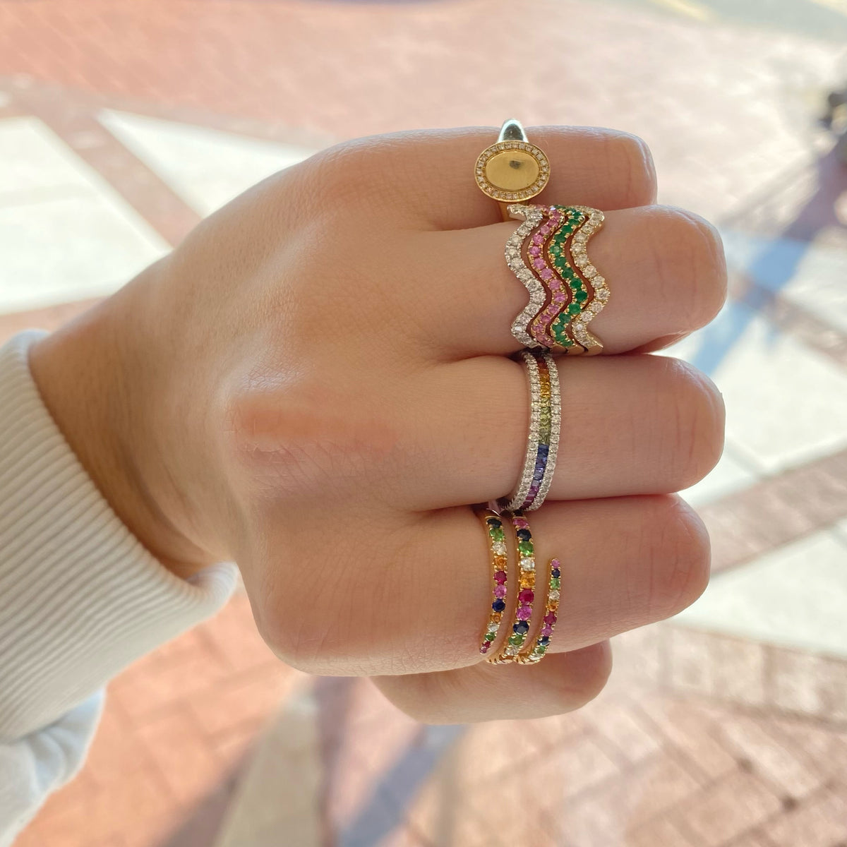 Female Model Wearing Pink Sapphire Stackable Wavy Ring  - 14K gold weighing 1.80 grams  - 19 pink sapphires totaling 0.32 carats