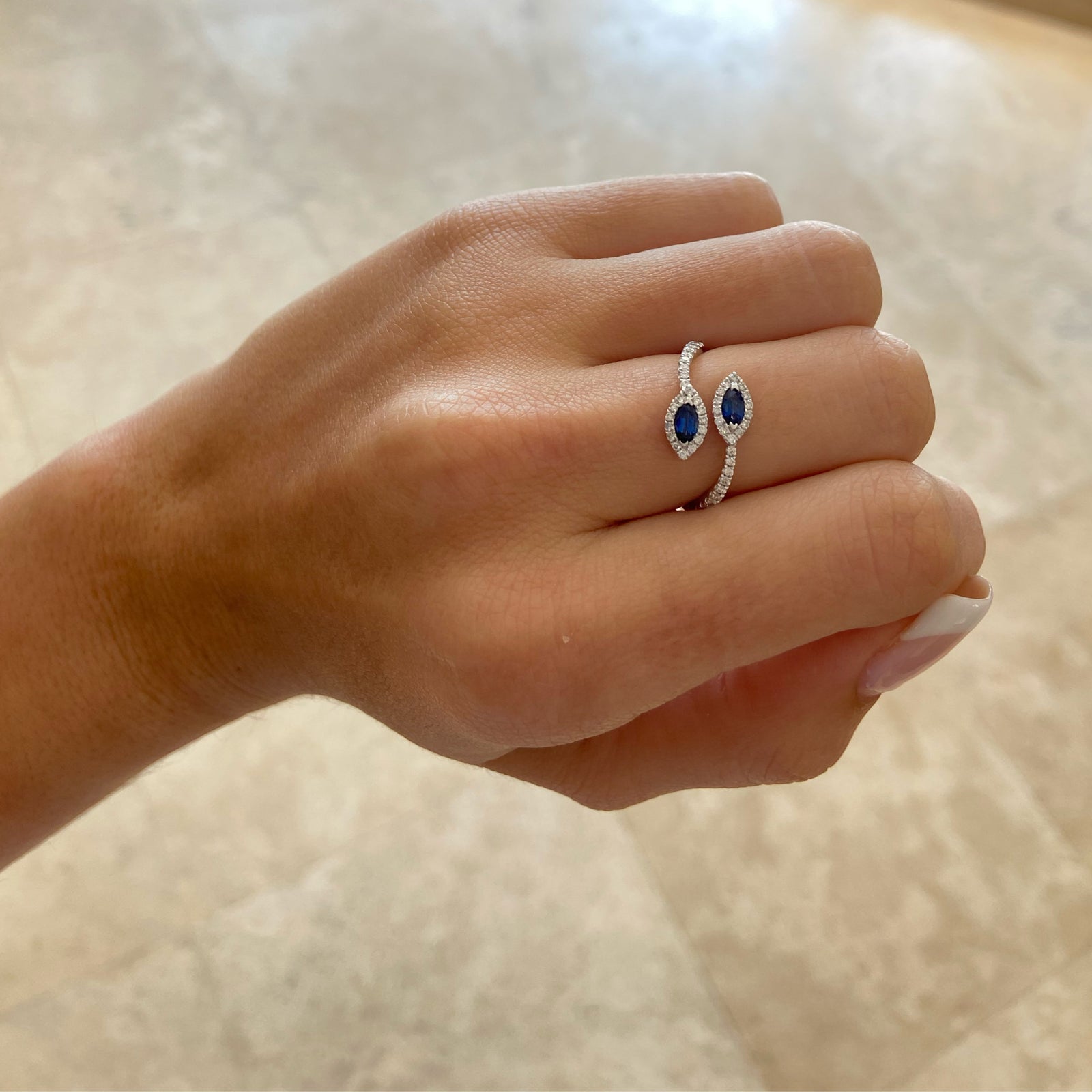 Sapphire Marquise & Diamond Open Ring  - 18K gold weighing 2.58 grams  - 50 round diamonds totaling 0.28 carats  - 2 marquise-shaped sapphires totaling 0.39 carats