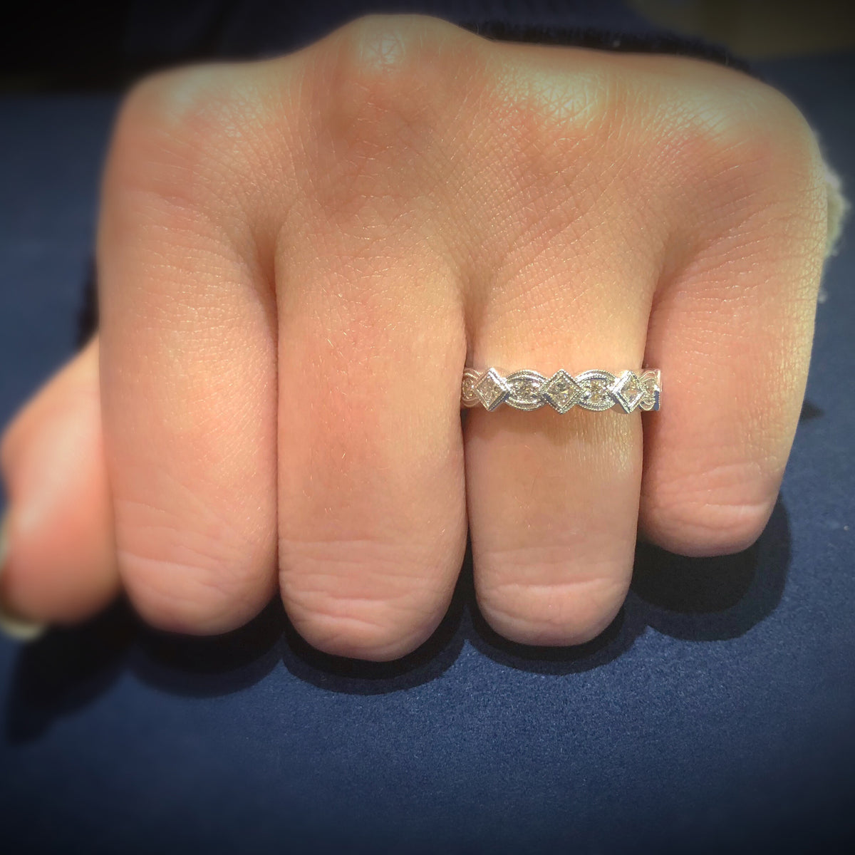 Female model wearing Geometric diamond eternity band ring -14k gold weighing 4.1 grams  -8 round diamonds weighing .24 carats  -9 PR weighing .68 carats