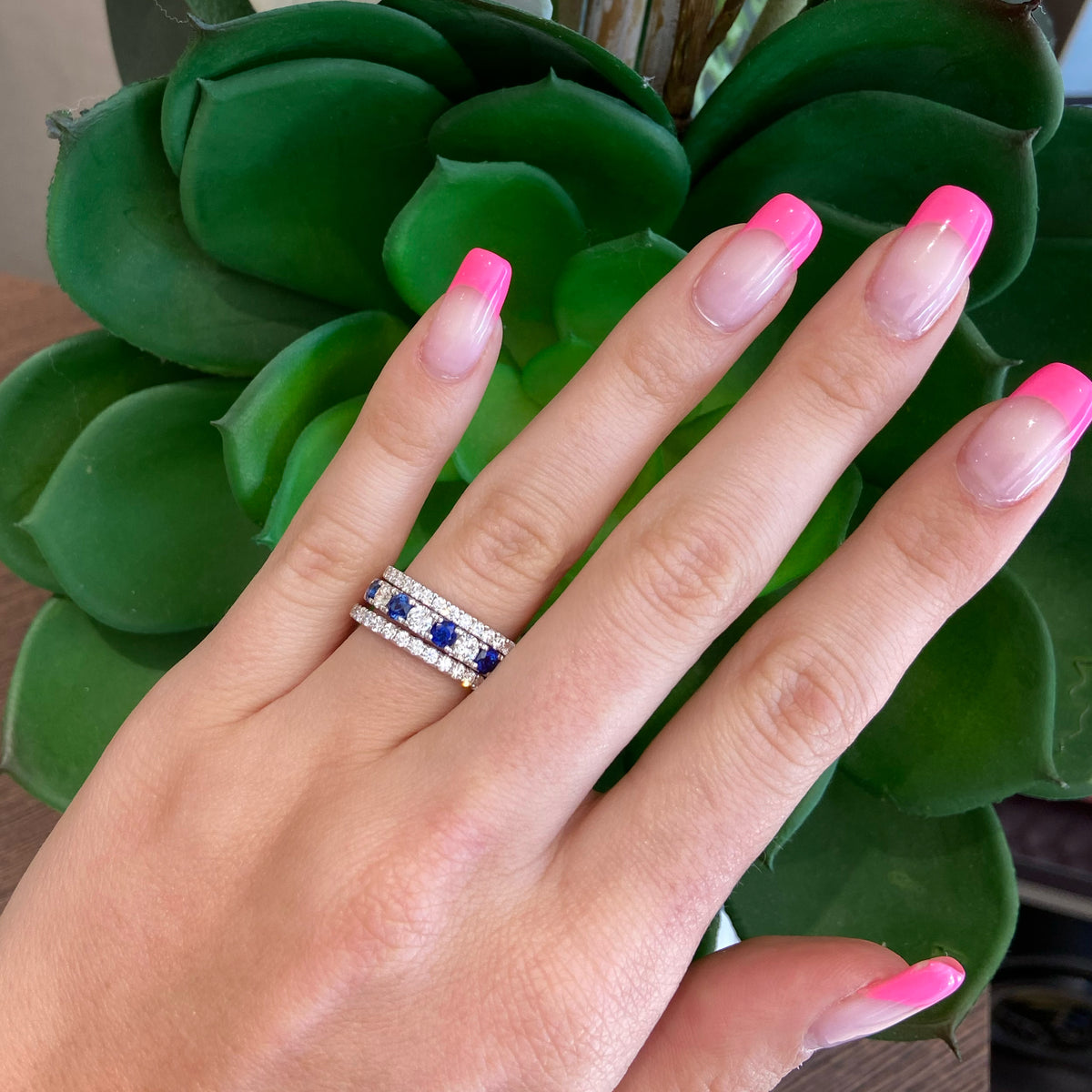 Female Model Wearing Sapphire & Diamond Wedding Band  -18K gold weighing 3.89 grams  - 5 sapphires totaling 1.09 carats  - 4 round diamonds totaling 0.49 carats