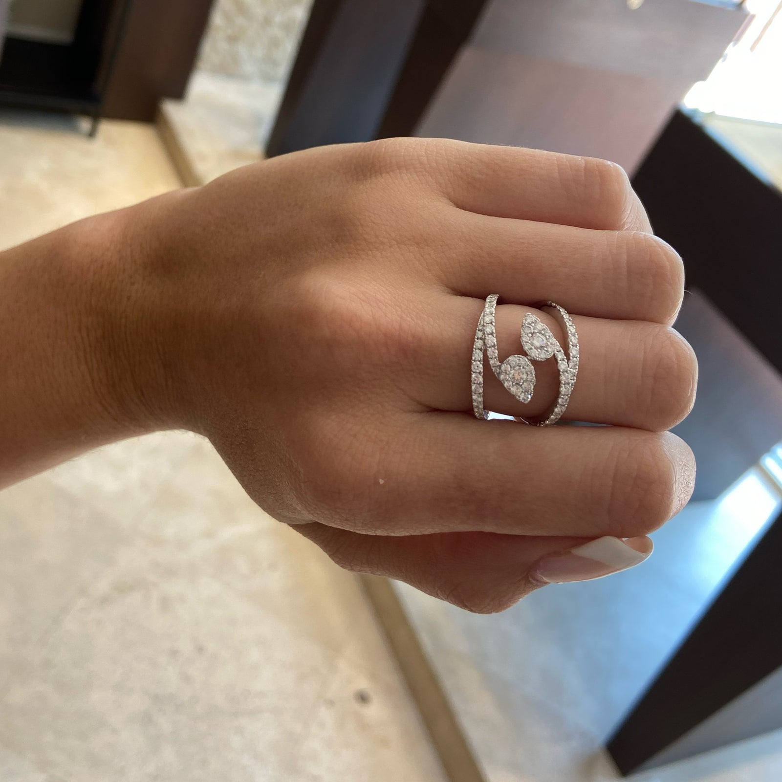 Diamond Teardrops Bypass Ring  - 18K gold weighing 5.31 grams  - 66 round diamonds totaling 1.06 carats  - 2 round diamonds totaling 0.19 carats