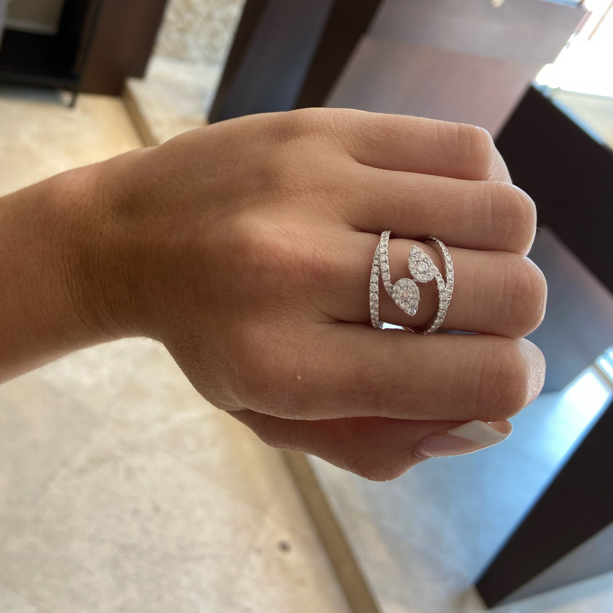 Diamond Teardrops Bypass Ring  - 18K gold weighing 5.31 grams  - 66 round diamonds totaling 1.06 carats  - 2 round diamonds totaling 0.19 carats