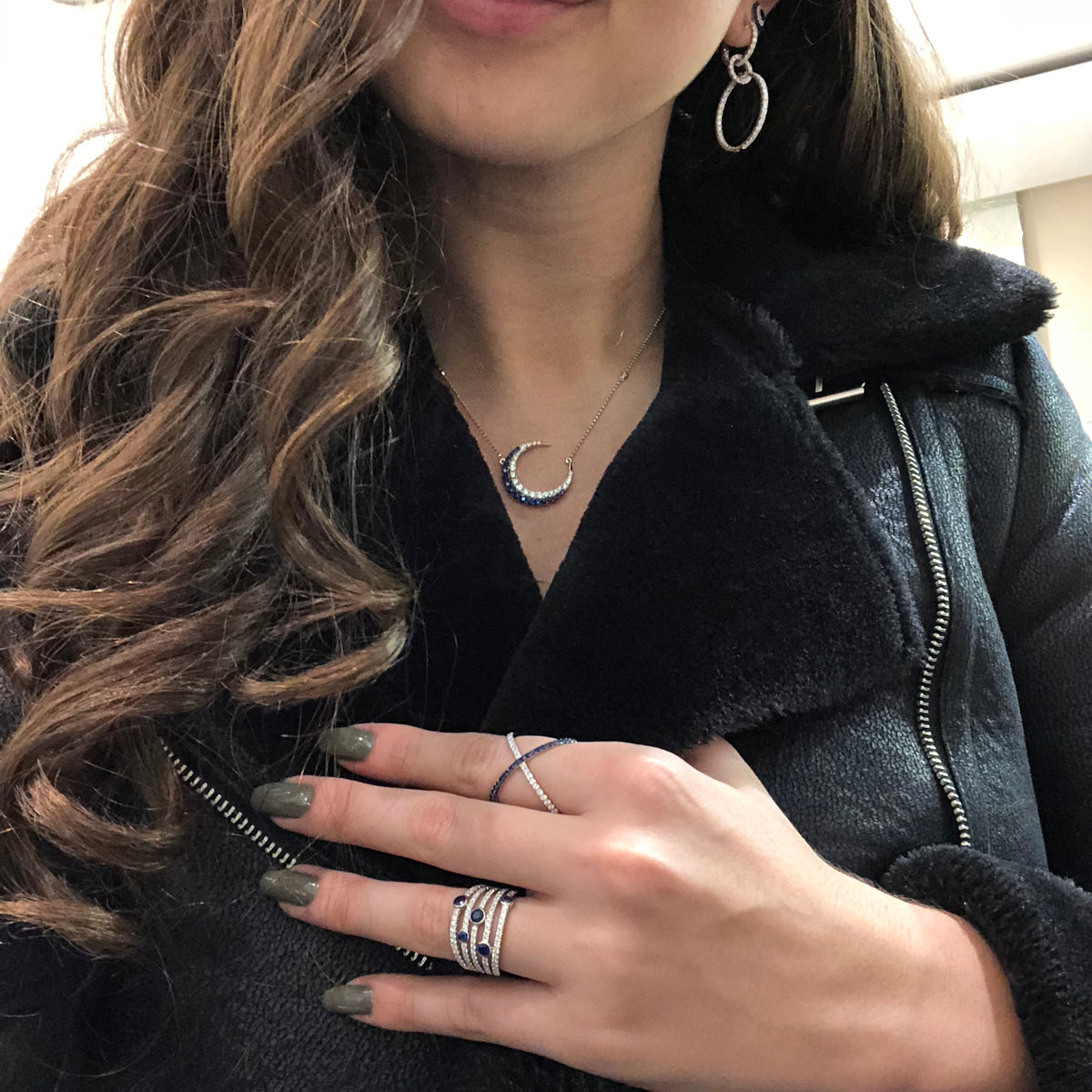 Female Model Wearing Diamond and Sapphire X Ring -18k gold weighing 3.83 grams  -20 round diamonds weighing .24 carats  -22 round sapphire gemstones weighing .33 carats