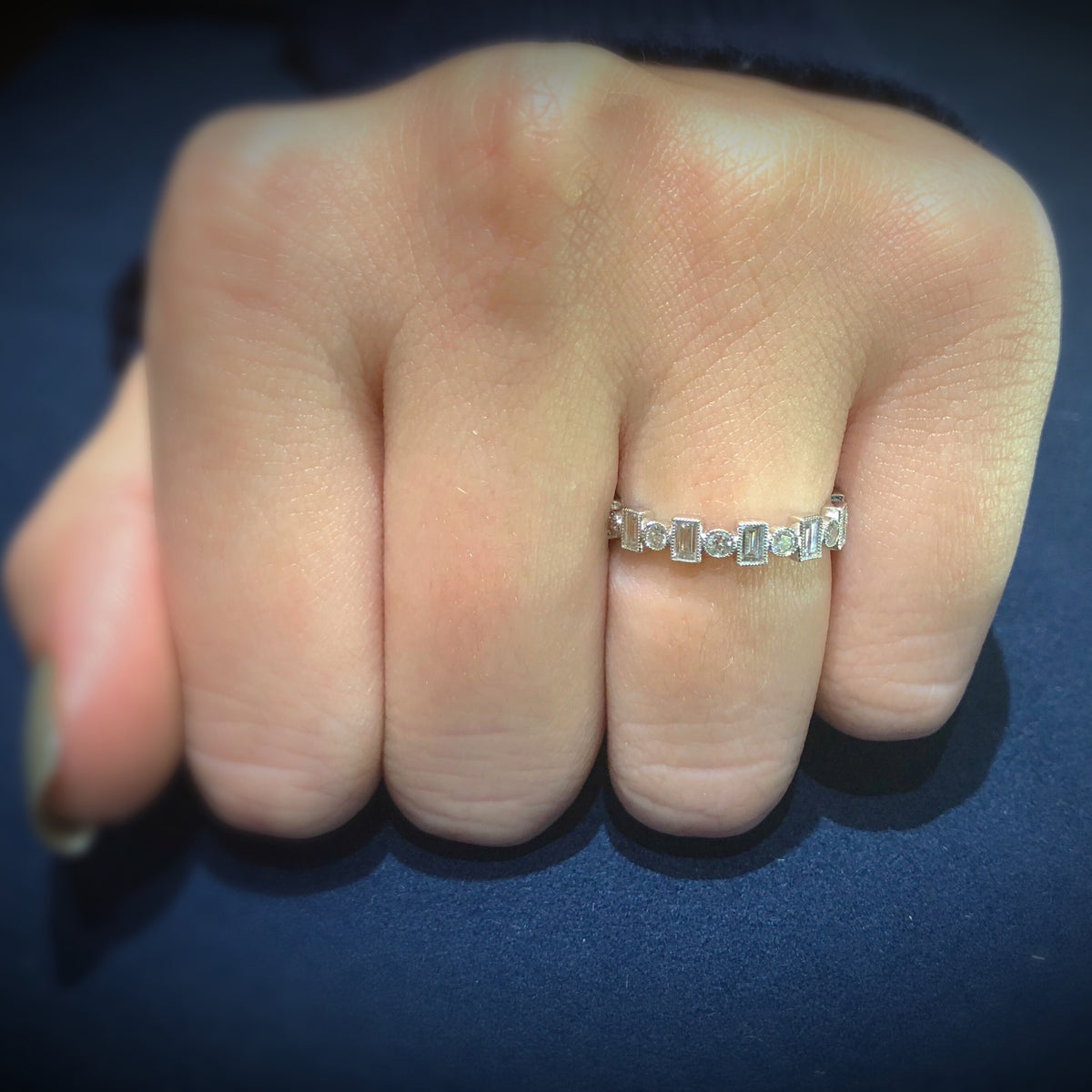 Female Model Wearing Alternating Round & Baguette Diamond Eternity Band with Milgrain  -18k gold weighing 2.19 grams  -12 straight baguettes weighing .89 carats  -12 round diamonds weighing .36 carats