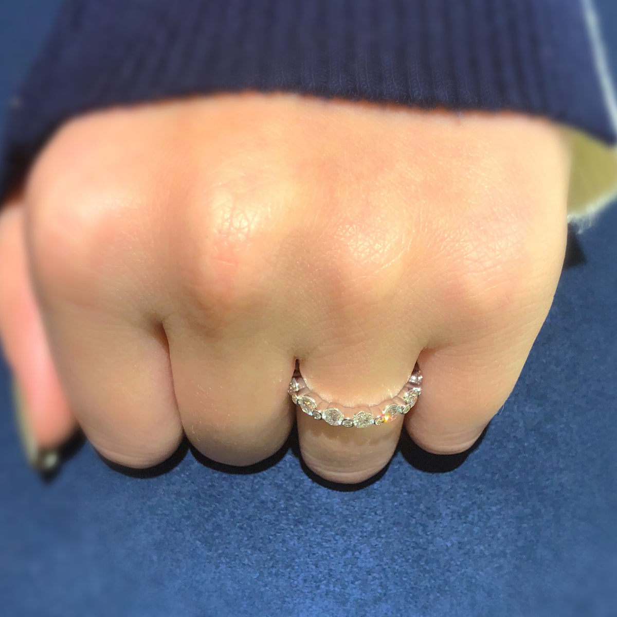 Female Model Wearing Single Prong Diamond Eternity Ring  -18k gold weighing 2.72 grams  -14 round bezel-set diamonds weighing 1.81 carats  -14 round bezel-set diamonds weighing .14 carats