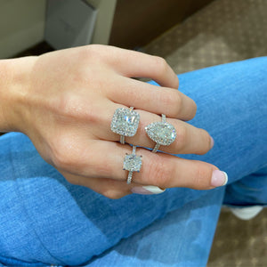 Female Model Weighting Princess-Cut Diamond Halo Engagement Ring  -18k gold weighing 5.7 grams  -40 round diamonds weighing .83 carats