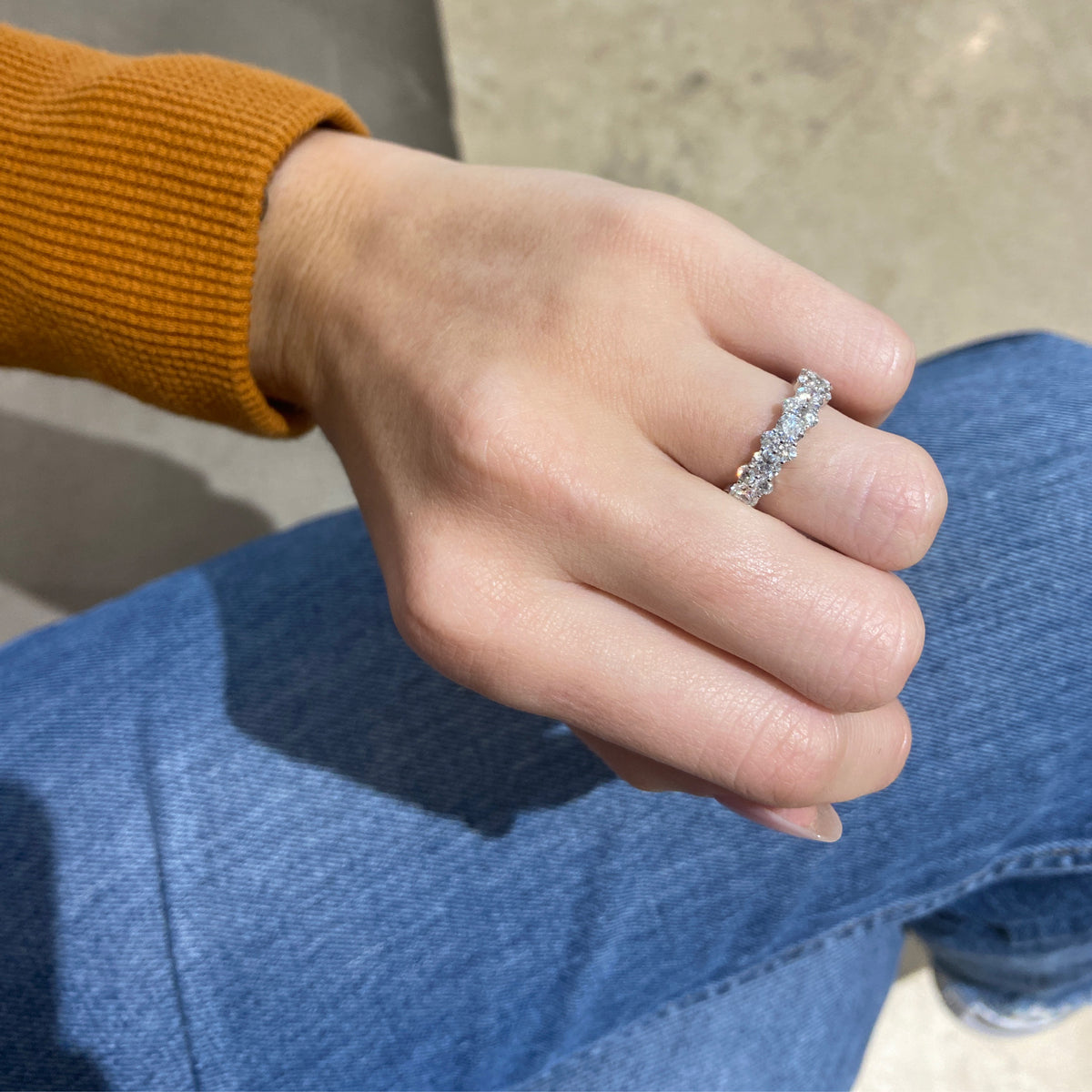 Female Model Wearing Staggered Diamond Eternity Band  -18k gold weighing 4.14 grams  -12 round diamonds weighing 2.40 carats  -24 round diamonds weighing 1.38 carats