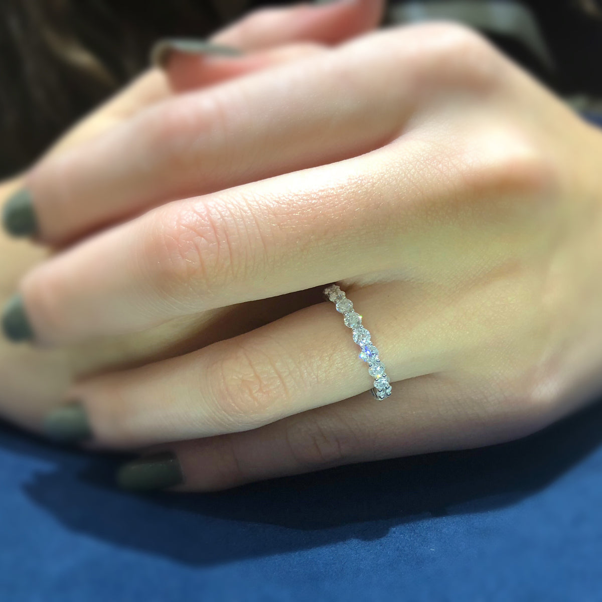 Female Model Wearing Shared Prong-Set Diamond Eternity Band  -18k gold weighing 1.94 grams  -21 round diamonds weighing 2.05 grams