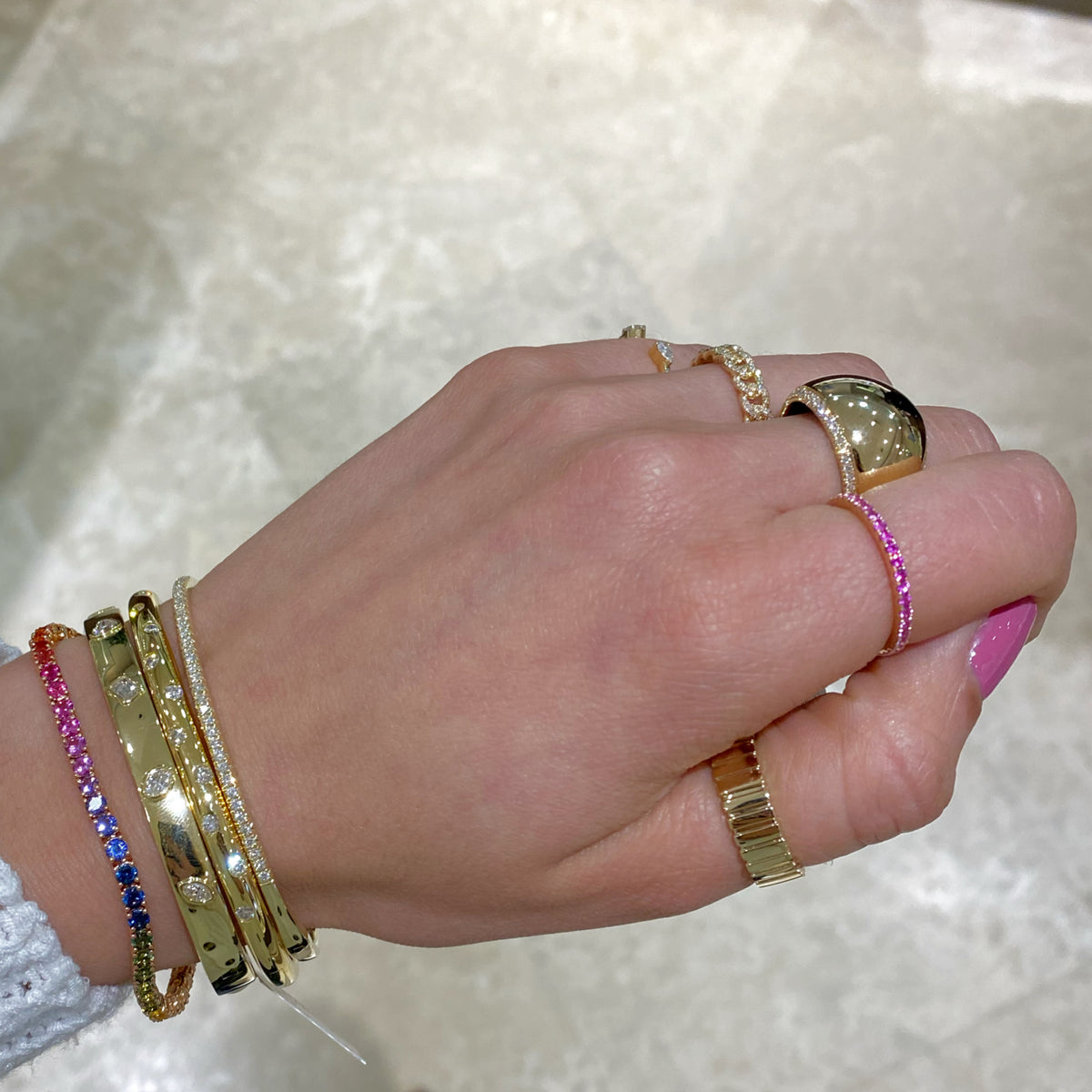 Female model wearing Multicolor Gemstone Tennis Bracelet - 18K gold weighing 8.26 grams  - 56 sapphires weighing 5.98 carats