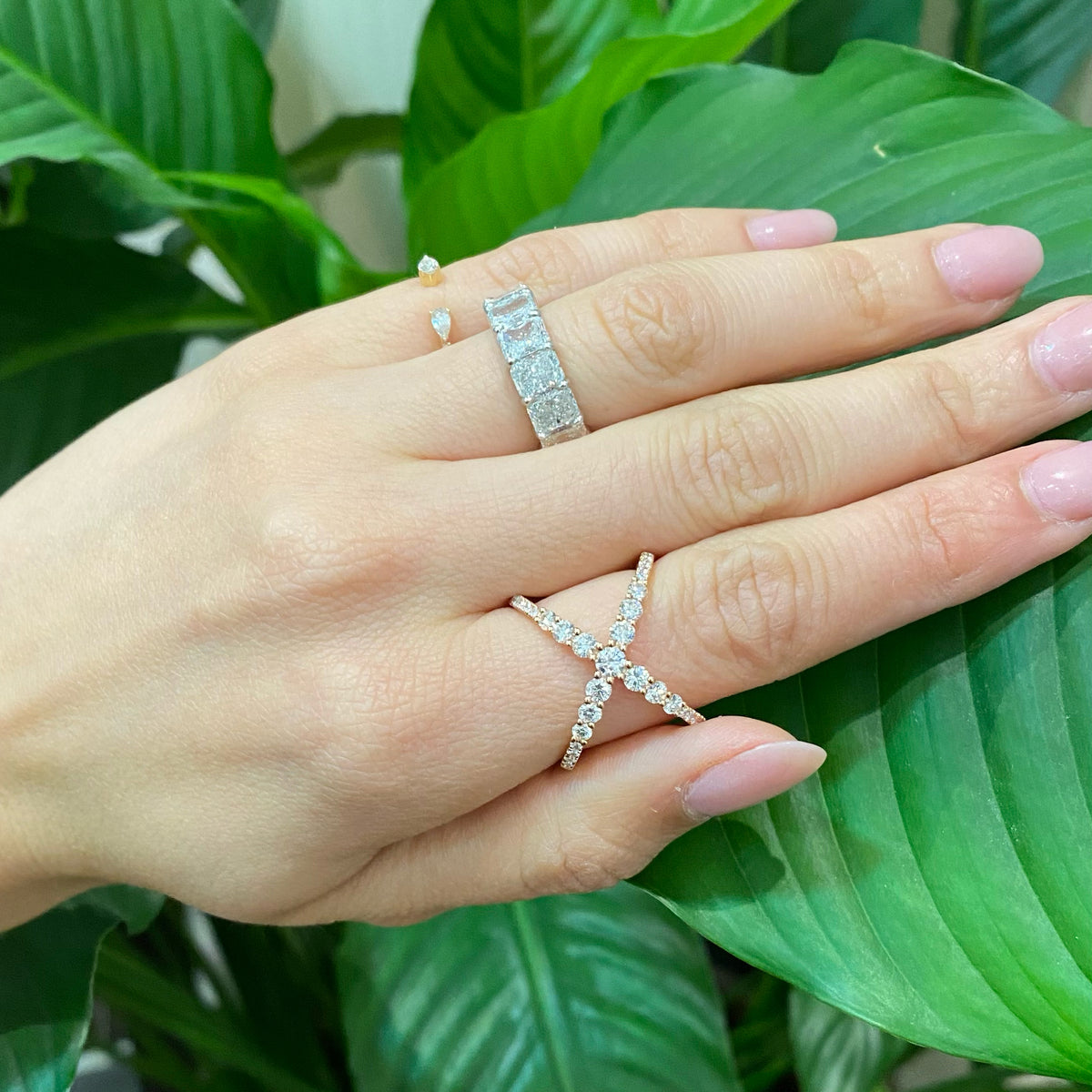 Female Model Wearing Diamond Criss-Cross Ring  -18K gold weighing 4.89 grams  -20 round diamonds totaling 0.17 carats  -13 round diamonds totaling 0.89 carats