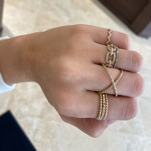 Female model wearing Diamond & Turquoise Eternity Ring  - 14K yellow gold weighing 0.71 grams  - 14 round diamonds totaling 0.07 carats  - 36 turquoise cabochons totaling 0.17 carats