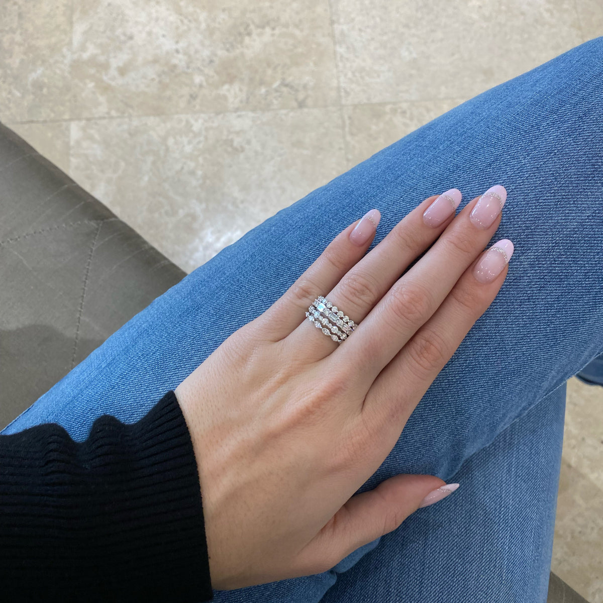 Female model wearing Round & Emerald-Cut Diamond Wedding Band - 18K white gold weighing 2.56 grams - 3 emerald-cut diamonds weighing 0.60 carats - 4 round diamonds weighing 0.52 carats